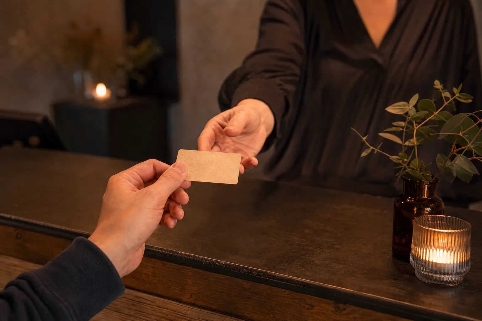 Närbild på en hand som håller ett vanligt restaurangpresentkort vid en restaurangreception