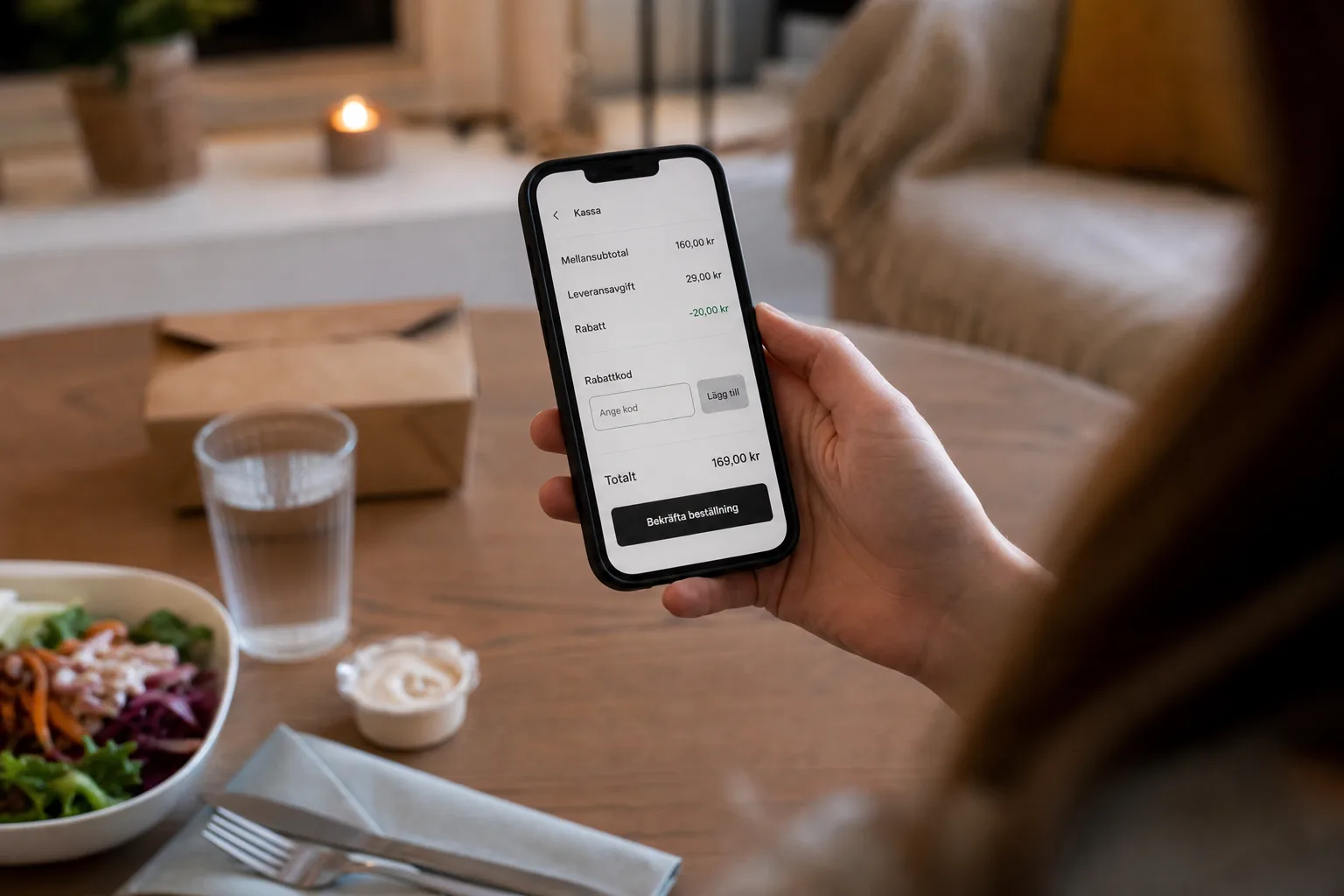 Person kontrollerar rabattfältet i kassan i en matbeställningsapp