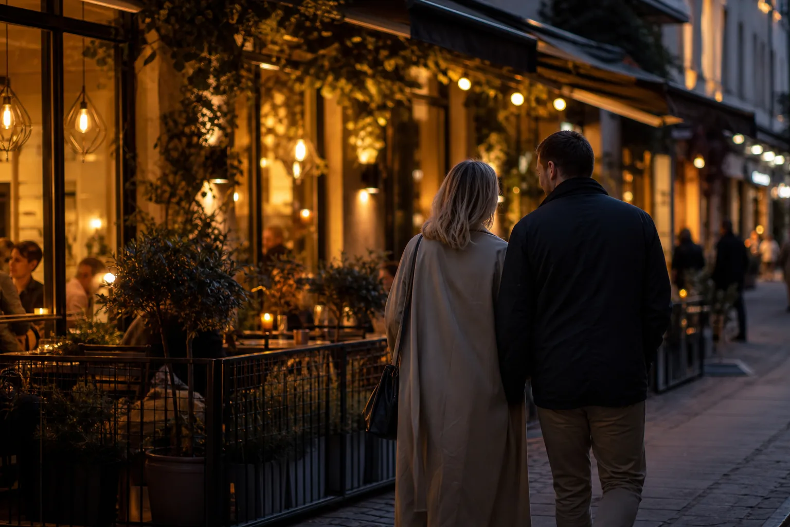 Ett par går längs ett livligt restaurangstråk en kväll i en västsvensk stad